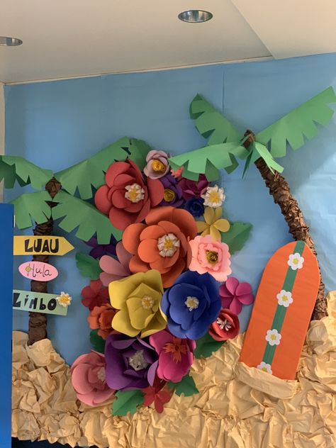 3D Pool noodle palm trees, cardboard surf board, and paper flowers for a photo backdrop. Ohana Bulletin Board Ideas, Hawaii Bulletin Board Ideas, Beach Hallway Decorations School, Moana Bulletin Board, Tropical Bulletin Board Ideas, Luau Backdrop Ideas, Hawaiian Bulletin Board Ideas, Lilo And Stitch Classroom Theme, Tropical Hallway