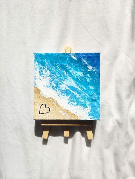 A hand-painted mini canvas painting of ocean waves meeting a beach with a heart drawn in the sand. Easel included. I'm more than happy to accept custom orders! Just give me a message. I pack all of my orders with recycled and recyclable materials to be as eco-friendly as possible! Ideas To Paint On Tiny Canvas, Beach Mini Canvas Painting, Miniature Acrylic Painting Mini Canvas, Easy Painting Ideas Beach, Tiny Acrylic Painting Mini Canvas, Mini Beach Paintings, Beach Easy Painting, Small Canvas Paintings Aesthetic, Tiny Painting Ideas