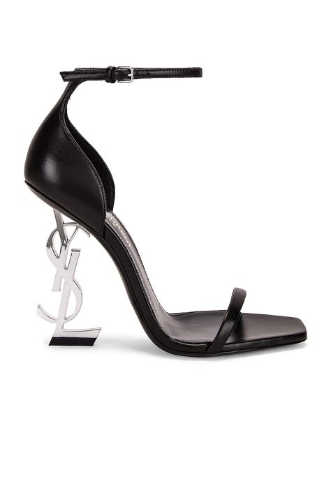 Find SAINT LAURENT Opyum Ysl Heels In Black on Editorialist. Saint Laurent Opyum YSL Heels in Black Lambskin upper with leather sole. Made in Italy. Ankle strap with buckle closure. Leather insole. Metal YSL initial sculptural heel. Polished silver-tone hardware. Open square toe. Approx 110mm/ 4.3 inch heel. SLAU-WZ874. 557662-AAABN-1000. About the designer: SAINT LAURENT has been influencing and revolutionizing the fashion industry since the debut of its iconic ‘Rive Gauche’ collection in 1966 - the couture house was the first to create a ready-to-wear capsule. The sleek, precisely tailored staples, like the signature biker jackets, transcend seasons and trends. Creative Director Anthony Vaccarello continues to honor the label’s illustrious reputation by reintroducing cult styles, includi Silver Shoes Heels, Club Heels, Formal Heels, Latest Sandal, Cute Shoes Heels, Ysl Heels, Crystal Sandals, Ysl Shoes, Anthony Vaccarello