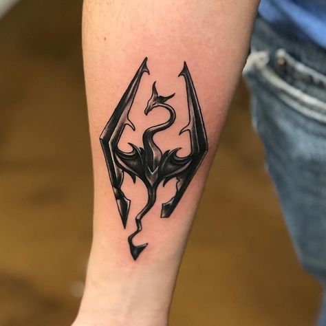 #Tattoos,skyrim tattoo Skyrim Symbol Tattoo, Skyrim Tattoo Design, Skyrim Logo Tattoo, Video Game Tattoo Ideas For Men, Skyrim Tattoo Sleeve, Alduin Skyrim Tattoo, Skyrim Dragon Tattoo, Sandevistan Tattoo, Gamer Tattoo Ideas