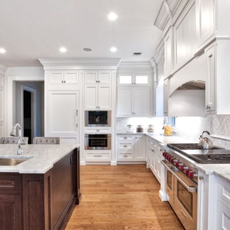 This large kitchen showcases a two-tone concept with an expansive dark wood island.   The transitional style makes the space feel rustic and traditional, but still has modern touches and accents. The cabinetry and island are all custom and done by our team at Teoria. Dark Wood Bottom White Top Cabinets, White Shaker Cabinets With Wood Island, White Kitchen Cabinets With Dark Wood Island, White Kitchen With Dark Wood Island, Kitchen White Cabinets Wood Island, Dark Wood Island With White Cabinets, White Kitchen Cabinets Wood Island, Dark Wood And White Kitchen, White And Dark Wood Kitchen