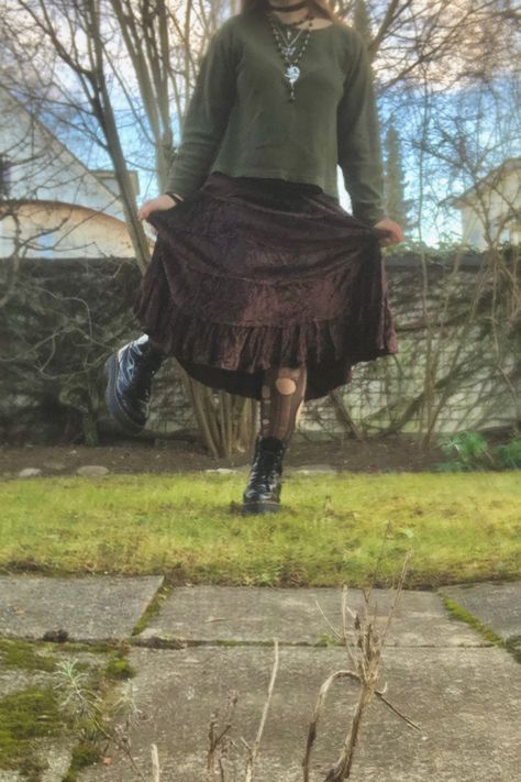 A mid-size person/girl wearing a dark brown maxi skirt and olive green sweater with ripped stockings. The person is also wearing multiple silver necklaces, one in form of a fairy on a moon, another in form of a butterfly. They are also wearing black platform dr. Marten shoes and multiple crystal rings. Fairy Grunge Aesthetic Outfit, Fairy Academia, Fairy Grunge Aesthetic, Grunge Fits, Fairy Outfit, Dream Aesthetic, Grunge Fairy, Hippie Vibes, Forest Floor