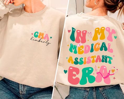 In My Medical Assistant Era Sweatshirt, Custom Medical Assistant Sweatshirtt, CMA Sweatshirt, Nursing Assistant, Nurse Healthcare Shirt by BlitzBazaar on Etsy Cna Shirts, Funny Wife Shirts, Funny Pregnancy Shirts, Kindergarten Teacher Shirts, Engagement Gifts For Her, Kindergarten Shirts, Bride Shirts, Funny Mom Shirts, Mama Sweatshirt