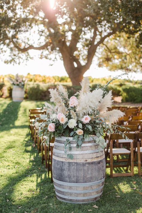 Country Wedding Isles Decoration, Simple Farmhouse Wedding Decor, Flowers On Barrels For Wedding, Wedding Planters Outdoor, Barrel Arrangements Wedding, Wine Barrel Ideas Wedding, Barrel Decor Ideas Wedding, Wine Barrel Floral Arrangement, Wedding Barrel Decor