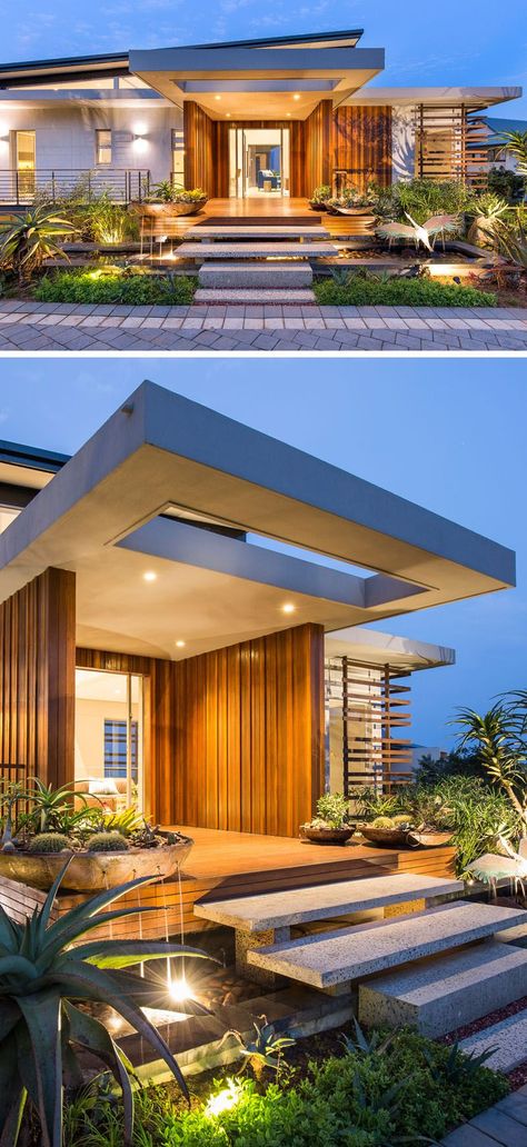 Uplighting, plants and a small pond welcome you to this home, while granite stairs that appear to be floating lead to the large front entrance of this modern home, that is adorned in timber cladding. Entrance Facade, Entrance Outdoor, Moderne Pools, Home Designs Exterior, Villa Project, Outdoor Window, Modern Entrance, Exterior Stairs, Cape Cod House