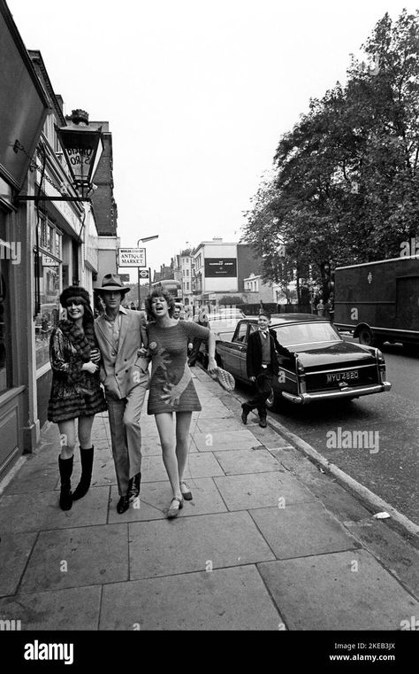 Download this stock image: London in the 1960s. Ulla Larsson and Birgitta Bjerke at 251 Kings Road in front of the Antique market stalls. They are wearing the very typical 1960s fashion of their own design. The man's identity is unknown. Picture taken during the era of the Swinging Sixties, a youth-driven cultural revoluton in the UK in the mid to late 1960s. Note the typical hand patterned clothing.  London England October 1967. - 2KEB3JX from Alamy's library of millions of high resolution stock photos, illustrations and vectors. Birgitta Bjerke, 1960s England, Unknown Picture, 1960s London, Swinging 60s, Mode Hippie, Swinging Sixties, Late 1960s, Market Stalls