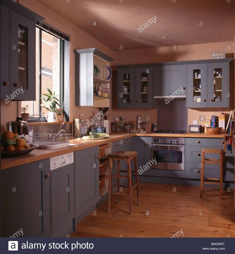 Download this stock image: Blue-grey fitted units and cupboards in terracotta country kitchen with wooden flooring and fitted dishwasher - BW2WET from Alamy's library of millions of high resolution stock photos, illustrations and vectors. Terracota Floor Kitchen, Blue Country Kitchen, Kitchen Cupboard Colours, Terracotta Kitchen, Cupboard Colors, Retro Homes, Grey Cupboards, Grey Blue Kitchen, Gray And White Kitchen