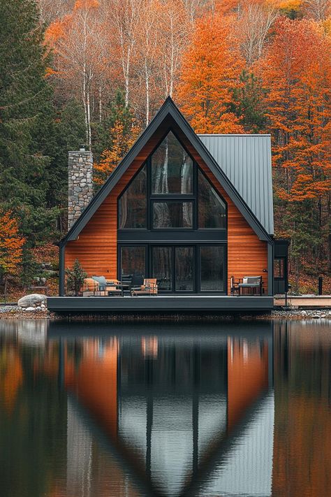 Modern a frame cabin with dark stained cedar siding large black frame modern windows and sliding doors grey metal roof in front of the house is a. Check out all of these stunning and chic dark A-frame houses that pack a ton of charm into a small forest retreat. A Frame Lake House Exterior, A Frame Cabin Exterior, Modern Lake House Exterior, Modern A Frame Cabin, Lake Houses Exterior, Modern Lake House, Modern Small House Design, A Frame House Plans, Cedar Homes