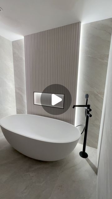 B3 design on Instagram: "Natural Stone Bathroom with Fluted Feature wall🤩🛁🤎✨🫧

▫️Fluted 3D feature tiles 
▫️Matt Stone Bath 🛁
▫️Large Format Natural Stone Tiles 
▫️LED lit pocket 
▫️Light Ash Wooden Vanity Unit 
▫️Black Accents with matching radiator 
▫️LED Round Mirror 🪞

#bathroom #bathroomdesign #bathroomdecor #flutedtiles #fluted #stonebath #freestandingbath #freestandingtub #tiles #stonetile #bathroominspiration #bathroominspo #bathroomrenovation #bathroomreno #bathroomremodel #home #homedecor #modernbathroom #mirror #bathroomstyle #b3design" Fluted Feature Wall, Fluted Tile Bathroom, Fluted Bathroom, Ribbed Tile, Wooden Vanity Unit, Swiss House, Natural Stone Bathroom, Natural Stone Tiles, Topps Tiles