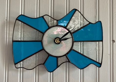 This retro "Modern Interesting Mid-Century" style wavy wall clock is made of stained glass using the copper foil or "Tiffany" style method. The colors are blue, textured bubbled glass and a iridescent white clock center. The seams are polished gray/black color with a clean lead came frame. Wavy Wall, Glass Wall Clock, Stained Glass Wall, Stained Glass Night Lights, White Clock, White Clocks, Practical Lighting, Wavy Design, Iridescent White