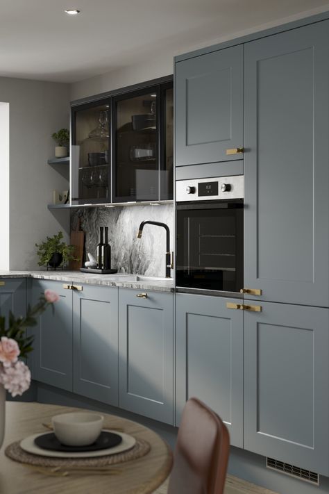 We are loving our new Chelford Dusk Blue Kitchen. Use this stunning traditional kitchen design to inspire your blue kitchen ideas. Use Grey Marble Effect laminate countertops and oak flooring to create a traditional kitchen design with a modern kitchen design feel. Finish with antique brass handles or antique brass kitchen hardware to add the finishing touches to your kitchen hardware. A black kitchen tap and dark glass kitchen cabinets create the perfect mdoern kitchen inspiration. Glass Finish Kitchen Cabinets, Chelford Dusk Blue Kitchen, Dusk Blue Kitchen Howdens, Dark Grey Marble Countertops Kitchen, Greyish Blue Kitchen, Dusky Blue Kitchen, Grey And Blue Kitchen Ideas, Grey Blue Kitchen Cabinets, Grey Oak Kitchen