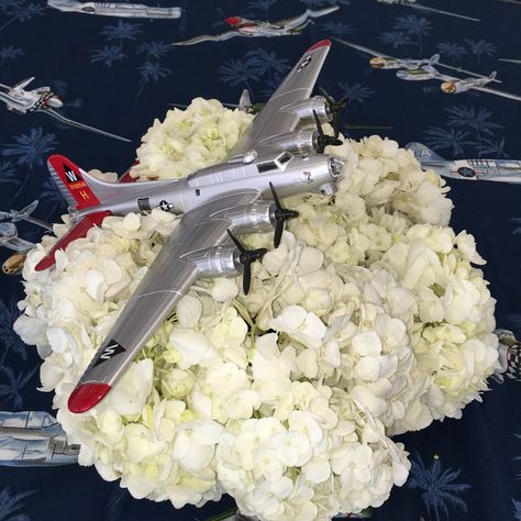 Airplane in the clouds centerpiece. B-17 model airplanes available at Lyon Air Museum. Centerpiece - hydrangea- flowers - airplane party lyonnaise museum.org Aviation Centerpiece Ideas, Airplane Engagement Party, Air Force Table Centerpieces, Aviation Centerpieces, Uso Party, Airplane Centerpieces, Airplane Centerpiece Ideas, Cloud Centerpiece, 1940s Party