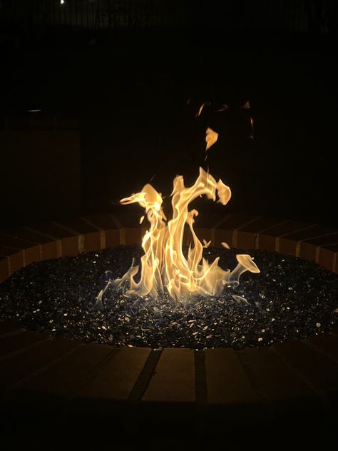 Outdoor fire pit with fire in motion in the center and blue glass stones around it. Fire Pit At Night, Fire Pit Aesthetic, Fire Pit Night, Glass Fire Pit, Stone Fire Pit, Fire Pit Seating, Outdoor Stone, Luxury Aesthetic, Helping Hand