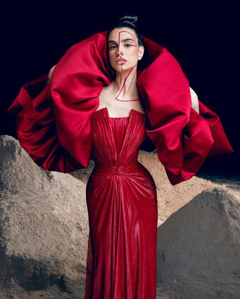 Red pleated lurex gown with a structured neckline- featuring a voluminous satin duchess shoulders cape.. Red Concert, Rami Kadi, Concert Poster Design, Shoulder Cape, Couture Looks, Strong Shoulders, Graduation Project, Concert Poster, Cape Sleeves