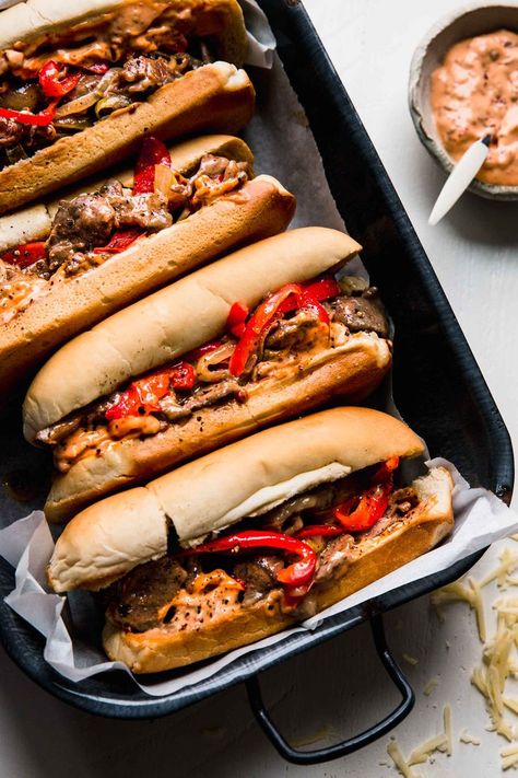 Cheesesteak Sandwiches are the ultimate comfort food. Juicy sliced sirloin, peppers, and onions piled into rolls & smothered with cheese. // recipe // philly Chicken Wing Soup, Chicken Wing Soup Recipe, Dinner Ideas Meatless, Philly Cheesesteak Sandwiches, Most Pinned Recipes On Pinterest, Steak Peppers, Sheet Pan Dinner Ideas, Cheesesteak Sandwiches, Hoagie Sandwiches