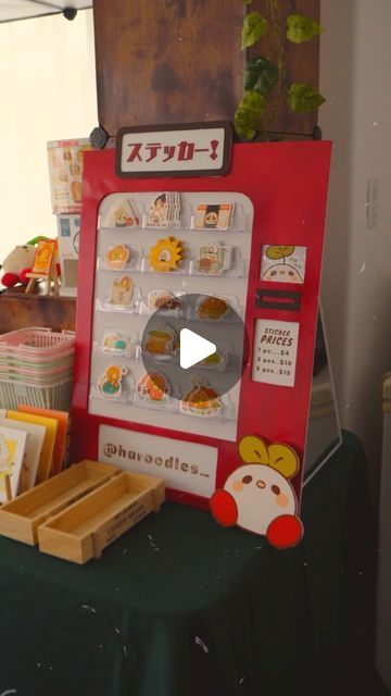 Haru Higa 🍏 on Instagram: "A little montage of me making my “vending machine” sticker display!!✂️✏️✨  When creating the concept for my booth, which ended up being themed after a little japanese corner store, I knew I needed at least one vending machine display😆  From my research about markets and art vending, I discovered that people love and are drawn to self-serve displays, and what is more “self-serving” than a vending machine!   I know this reel isn’t very in-depth, but I was under a huge time crunch to get my booth finished, so filming wasn’t my priority. But comment and let me know if you’d like me to do youtube vlogs + reels in the future of how I go from a concept to the finished product!  And let me know what you’re most interested in seeing me create! Displays? Stickers? Charms Vending Machine Ideas Diy, Diy Art Market Display, Japanese Corner Store, Vending Machine Art, Diy Vending Machine, Art Market Display, Vending Machine Diy, Artist Alley Table, Display Craft Fair