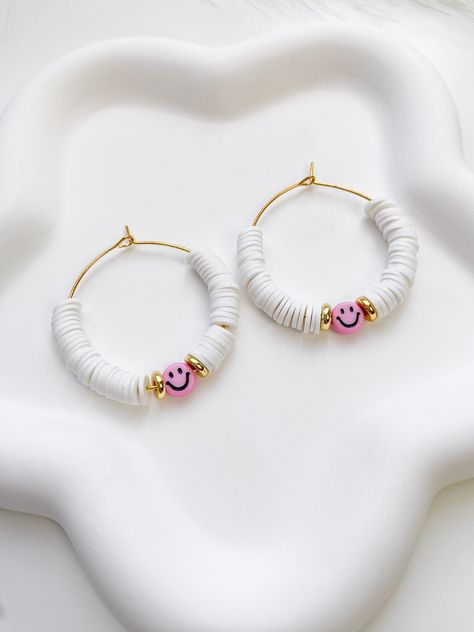 Brighten your outfit with these beautiful smiley heishi bead earrings. ITEM DETAILS  ⭐ 35mm Stainless steel hoops ⭐ Heishi beads ⭐ Acrylic smiley beads ⭐ Stainless steel disc beads CARING TIPS  🤍 Keep your jewelry dry and away from perfumes or any harsh chemicals 🤍 Store your jewelry separately, avoid wearing it if you are going to work out. Thank you so much for visiting my shop! Have fun creating your favorite combinations and enjoy your new jewelry! Preppy Earrings Bead, Heishi Clay Bead Earrings, Affordable Handmade Heishi Beads Earrings, Clay Disc Earrings, Cheap Heishi Beads For Festival, Cheap Heishi Beads For Festivals, Cheap Handmade Heishi Bead Earrings, Cheap Trendy Heishi Beads, Flat Clay Bead Earrings