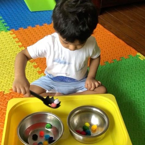 Prachee | Play Ideas & DIYs on Instagram: "#MOTORSKILLMONDAY |Pom-Pom Transfer Activity with a slotted spoon| Water, colourful little balls and kitchen utensils are a perfect recipe of fun and laughter for toddlers . Vihaan has been enjoying various variations of this Pom Pom transfer activity since he was 15 months old. All you need is some medium sized pom pom balls, child sized spoons, a few containers and a big basket or mat to contain mess from water :) If you don't have pom poms, then yo 15 Month Old Activities, Pom Pom Balls, Toddler Class, Popcorn Bowl, Big Basket, Nursery Activities, Slotted Spoon, Play Ideas, Toddler Learning Activities