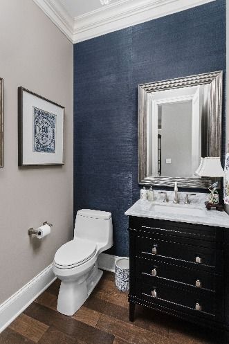 The bathroom incorporated colors gray, navy, white, and wood accents. To create more visual interest and texture to the space we added a navy accent wall. The artwork ties in perfectly to the space with the white and shades of blue. Gray is used on the walls and the outline of the mirror. Let's not forget about the beautiful light fixture! The light fixture enhances the stunning space. Photography by The Home Aesthetic. Navy Accent Wall Bathroom, Navy And Gray Bathroom, Blue Accent Wall Bathroom, Blue Bathroom Accents, Blue Bathrooms, Taupe Bathroom, Blue Bathroom Walls, Navy Accent Walls, Dark Blue Bathrooms