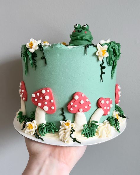 Funky froggy feels 🐸🍄🌿🌼🌾 • • Order sweet swampy cakes on our website 🔗 in bio! • • #frogcake #buttercreamcakes #buttercreamcake #buttercream #buttercreamart #customcake #cakedecorating #cakestagram #cakedesign #instacake #cakeideas #vermontbakery #vermontbaker #homebaker #homebakery #bakergram #vermont #madeinvermont #madeinvt #shelburnevermont #shelburnevt #bluehousebakeshop #cake #baker #pastrychef Buttercream Mushroom Cake, Frog Mushroom Cake, Mushroom Cake Design, Bug Cake Ideas, Character Cake Ideas, Decorated Cakes Ideas, Mushroom Cake Ideas, Half Moon Cake, Garden Cake Ideas