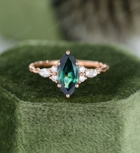 Marquise Blue green sapphire engagement ring Unique Rose gold engagement ring vintage Marquise cluster ring Bridal promise Anniversary gift ITEM DESCRIPTION: Center stone: Blue green sapphire Size: 5*10 mm Shaped: Marquise shaped Side stone: 0.12ct moissanite or 0.22ct diamond Color/Clarity: G-H,SI1-VS Width of band: 1.5mm Thickness of band: 1.2mm Total weight: 2.4g Materials (can select from drop-down menu): 14K Solid gold/ 18K Solid gold ( Rose gold, Yellow gold, White gold) Size: all ring siz Vintage Marquise Engagement Ring, Sapphire Engagement Ring Unique, Rose Gold Moissanite Engagement Ring, Blue Green Sapphire Engagement Ring, Green Engagement Rings, Blue Green Sapphire Ring, Unique Engagement Rings Rose Gold, Moissanite Engagement Ring Rose Gold, Green Sapphire Engagement