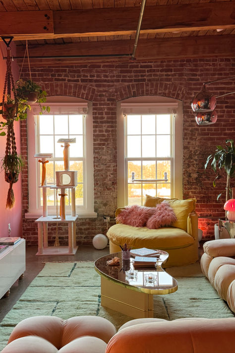 A beautifully decorated girly apartment living room featuring cozy furniture, pink accents, a chic coffee table, trendy wall art, and unique lighting solutions. The image showcases a harmonious blend of modern and vintage elements, creating a warm and inviting atmosphere perfect for inspiration. Loft Apartment Colorful, Girly Loft Apartment, Living Room Pink Accents, Boho Vintage Living Room, Vintage Eclectic Living Room, Apartment Colorful, Home Decor Girly, Girly Living Room, Girly Home