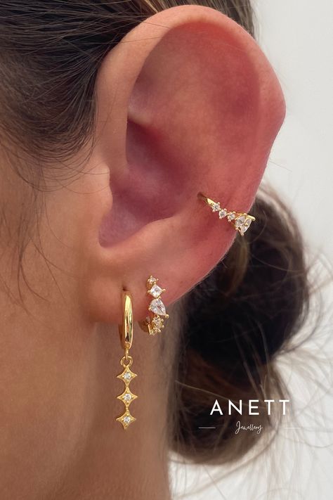 A. Ellie Drop: The earrings feature small gold hoops from which delicate chains hang. Each chain holds three star-shaped pendants which adorned with tiny cubic zirconia adding a touch of sparkle. • Material: 18k gold plated on 925 Sterling Silver, AAAAA Cubic Zirconia • Size: Inner hoop diameter: 9mm , Length: 27mm #The #Mastering #of #Art #Stack #Tidiness #of #StatementJewelry #Jewelry #of #Adornment #Jewelry #the #the Gold Earrings Hanging, Gold Earrings Set, Jewelry Stack, Adornment Jewelry, Pretty Jewelry Necklaces, Small Gold Hoops, Piercing Inspo, Stacked Earrings, Jewelry Photoshoot