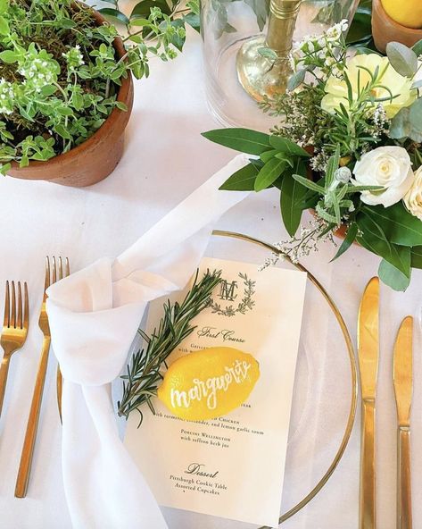 Rosemary and calligraphy name on lemon with gold and white plates. Featuring seasonal flowers, herbs. Lemon Place Setting, Wedding Cocktail Hour Decor, Rosemary Wedding, Cocktail Hour Decor, Potted Herbs, Unique Calligraphy, Lemon Wedding, Wedding Cocktail Hour, Cookie Table