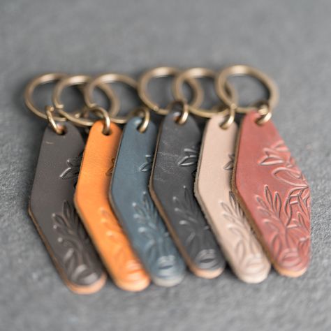 "Keep track of your keys in style with these premium leather keychains available in 6 colors. Choose a design to make your motel keychain stand out. You won't find better quality leather than this. Made by hand in our workshop in the USA! DETAILS: -Leather Length: 3.5\"  -Leather Width: 1.5\" -Antique brass keyring -Leather Color Options: Sienna, Stone Natural, Black, Deep Ocean, Harvest, Black Brown -Made in the USA -Each sold separately STAMP DESIGN OPTIONS: -Wanderlust -Blessed -Drive Safe -E Keychain Stand, Leather Keychain Diy, Brass Keyring, Motel Key, Leather Keychains, Motel Keychain, Diy Leather Projects, Leather Scrap, Leather Engraving