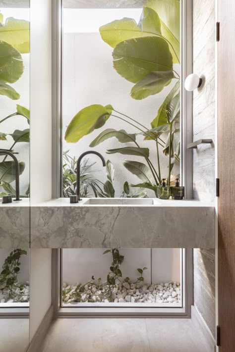 A floor-to-ceiling window captures the surrounding landscape, this bathroom also features a stone vanity and brushed gunmetal tapware. Powder Room Modern, Palm Springs Modern, Abi Interiors, Business Interior Design, Bathroom Design Small Modern, Geometric Structure, Modern Coastal Home, Business Interior, Interior Architecture Drawing