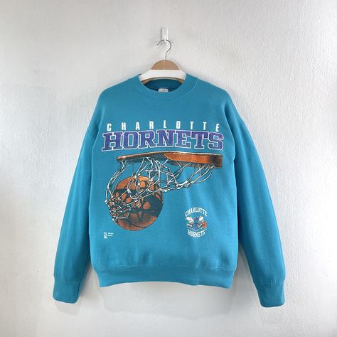 Vintage 90s Charlotte Hornets NBA Basketball Crewneck Sweatshirt Team Sportswear  Condition : Used vintage Good conditions Details : stains (Look at the picture) Please Let me know if you have any      questions or More Photo Detail Brand : Fan Sportswear  Made in : USA  Measurement Size On Tag : L, (fit like M) Pit to pit : 22 inches Length : 26.5 inches Material : Cotton Polyester Color : Blue  *Please keep in mind that our items are vintage so they may show some signs of wear and tear *Please read everything before buying  No Cancel  No Refund  No Return  Please give us your phone number together with address after you purchasing.( No P.O Box  shipping to worldwide Item will shipped in 1-3 days after payment. ( remote area The shipping cost is higher) Thank you :) Vintage Basketball Shirts, Vintage Basketball Graphic Tees, Hornets Jersey, Vintage Crew Neck Sports T-shirt, Vintage Charlotte Hornets, Vintage Sportswear, Charlotte Hornets, Vintage Apparel, Nba Basketball