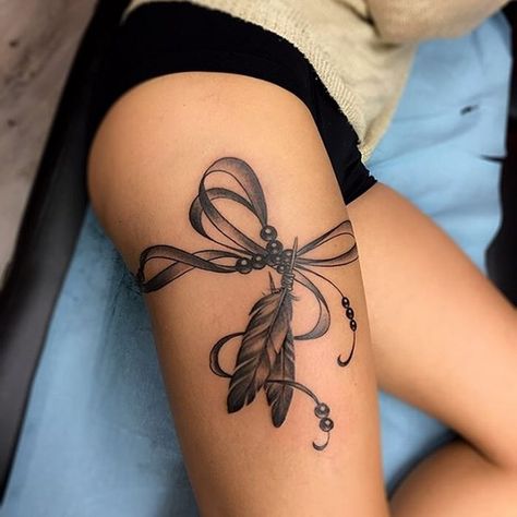 elegant feather tattoo on thigh Bracelet Tattoos, Tattoo Feather, Garter Tattoo, Thigh Tat, Hip Thigh Tattoos, Acrylic Ideas, Bow Tattoo, Flower Sleeve, Thigh Tattoos