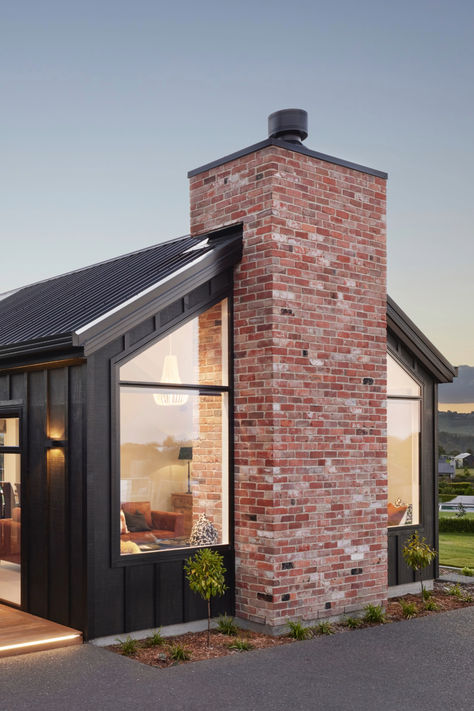 Head to https://www.signature.co.nz/plans/ for more custom built homes.  #brickhome #brickchimney #brickcladding #brickexterior #exteriorhomedesign #chimney #exteriorfeature #homedesign #exteriorfacade #blackhome #darkhome #redbrick #sanselmobrick #featurebrick Nz House, Brick Cladding, Brick Chimney, Brick Home, Dark Home, Custom Built Homes, Red Bricks, Exterior Brick, Brick House