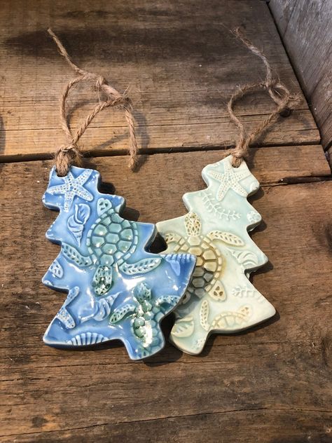 "SEA TURTLE ORNAMENT - Sea turtles are swimming all over this tree ornament! A mix of the beach and Christmas - my two favorites! 🌲🐢 - Approx 5\" tall - Non toxic/Lead Free  - Jute hanger - Back is unglazed - Other color options available upon request *handmade pottery- may vary slightly from photo. Pattern of turtles will vary as well" Pottery Tree Ornaments, Chrismas Crafts, Beach Christmas Trees, Pottery Christmas, Turtle Ornament, Ceramic Christmas Decorations, Pottery Ornaments, Wool Appliqué, Clay Christmas