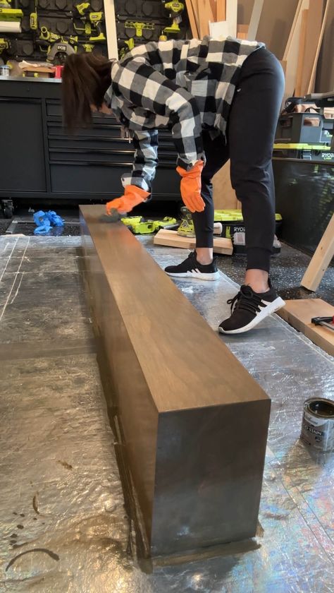 Melissa Tyler staining her DIY fireplace mantle. Staining Fireplace Mantle, Diy Floating Mantle Shelf, Build Mantle Fireplace, Mantle Diy Wood How To Build, Black Walnut Mantle, Black Fireplace Wood Mantle, Drywall Fireplace With Mantle, Diy Mantle Fireplace, Diy Floating Mantle