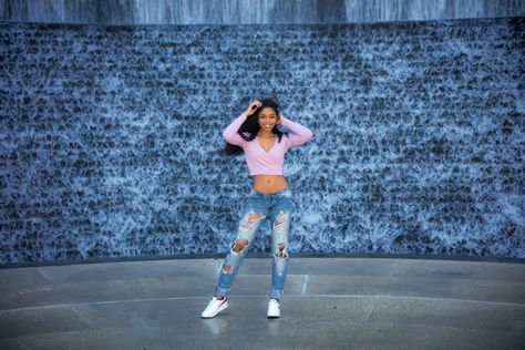 A young woman poses facing forward in front of a waterwall in Houston Winter Photoshoot, Houston, Photography