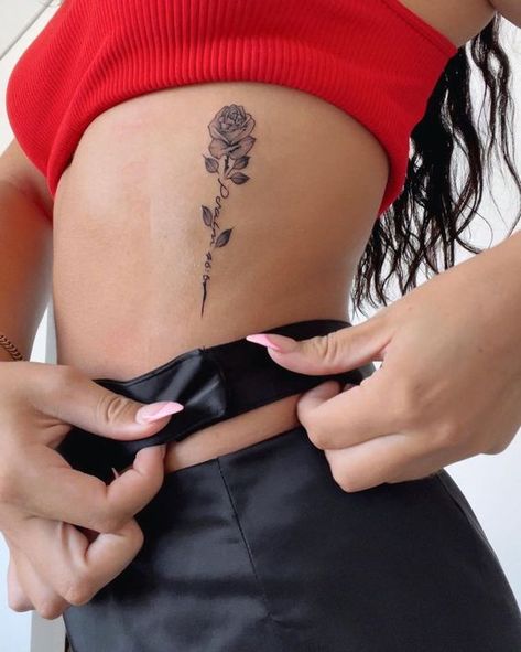 Rose With Bible Verse Tattoo, Rose Tattoos Ribs, Rose Bible Verse Tattoo, Bible Verse Tattoo With Cross, Rose Side Rib Tattoo, Rose Cursive Tattoo, Name In A Rose Tattoo, Cute Tattoos On Ribs, Cross Rose Tattoo For Women