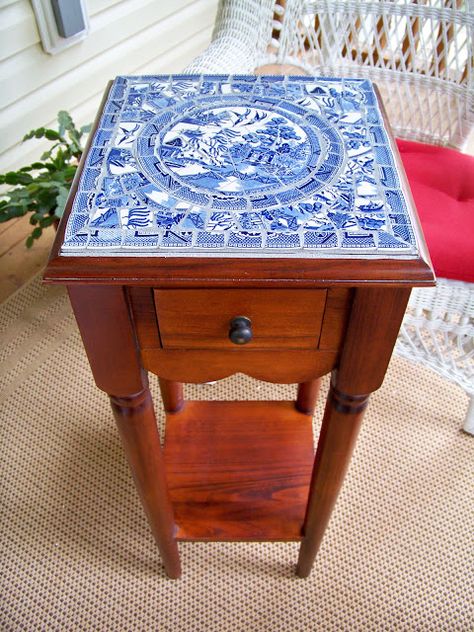 To bring an ordinary end table to life, create a simple mosaic tabletop using broken china on the surface. The two-toned blue-and-white pattern brings a surprising pop of color to plain wood. Broken China Crafts, Mosaic Furniture, Blue Willow China, China Crafts, Mosaic Table Top, Mosaic Table, Mosaic Garden, Broken China, Blue And White China