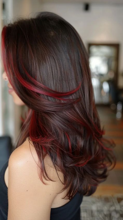 Woman with long, wavy dark brown hair featuring red highlights. Brown To Cherry Red Balayage, Red Balayage Dark Hair, Brunette Red Hair Balayage, Brown With Colored Highlights, Cute Red Hair Dye Ideas, Red Balayage Straight Hair, Burgundy Hair Color With Highlights, Brown Hair With Cherry Red Highlights, Dark Brown And Red Hair Balayage