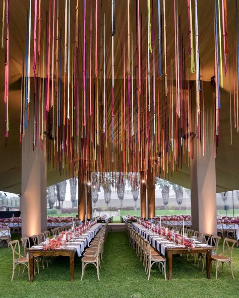 The bride from today’s #WeddingOfTheDay celebrated her Peruvian heritage by surrounding her guests with local accents like this formal dinner beneath a colorful installation of quipus, an Incan craft historically used for counting 🌈 See more of the unique details from this fun destination wedding through the link in bio! | #BridesRealWedding 📷: @elmarcorojo 📋: @jgroupevents 💐: @fdbeventos 🏡: El Jockey Club de Peru Wedding In Peru, Peruvian Wedding Ideas, Peruvian Theme Party, Peruvian Wedding Decorations, Ecuadorian Wedding, Peruvian Inspired Wedding, Peruvian Wedding, Peruvian Decor, Peru Wedding