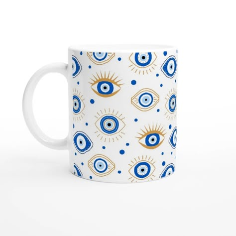 The Evil Eye Mug is the perfect addition to any coffee or tea lover&#39;s collection. This ceramic mug features a bold and striking blue evil eye pattern, inspired by the traditional Turkish and Greek symbols of the &quot;Evil Eye.&quot; Evil Eye Mug Design, Evil Eye Pottery Painting, Turkish Vibes, Evil Eye Mug, Greek Symbols, Evil Eye Pattern, Ceramic Eye, Greek Symbol, Greek Eye