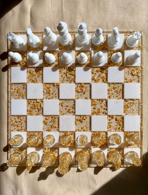 This exquisite handmade custom-made resin chess set is the perfect blend of artistic craftsmanship and timeless strategy for chess enthusiasts and collectors alike. Each piece is meticulously handcrafted from premium quality resin, ensuring a durable, yet elegant finish. These shimmering metallic flakes imbue each piece with a touch of opulence, creating a mesmerizing visual experience as you engage in the age-old game of kings. This one-of-a-kind chess set is not only a functional game board bu Fancy Chess Board, Resin Ideas For Men, Chess Resin, Resin Games, Resin Chess Board, Resin Chess Set, Kings Game, Games Board, Diy Resin Crafts