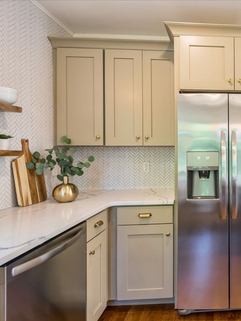 Timeless yet trendy Taupe is back in this Shaker kitchen by Cabinets.com designer Cally. Its gray-brown tones pair neatly with the white herringbone backsplash. Beige Kitchen Cabinets With Stainless Steel, Taupe Cabinets Kitchen, Kitchen Taupe, Tan Kitchen Cabinets, Taupe Cabinets, White Herringbone Backsplash, Living Remodel, Taupe Kitchen Cabinets, Beige Kitchen Cabinets