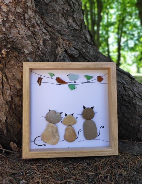 Art Frame Of Pebbles With Cats And Birds Handmade wooden frame with natural materials. Carefully selected unique sea pebbles and sea glasses. An original and wonderful idea for any occasion. Frames can be customized. If you want to add text to make the gift even more personal, please mark this in the free personalization field when ordering. DETAILS: The size of the frame is 19cm x 19cm, it is ready for hanging, there is no glass in the front. Cat Pebble Art, Rock Pictures Diy Pebble Art, Framed Rock Art, Pebble Art Cats, Seaglass Diy, Diy Pebble Art, Pebble Art Ideas, Shell Paintings, Cats And Birds