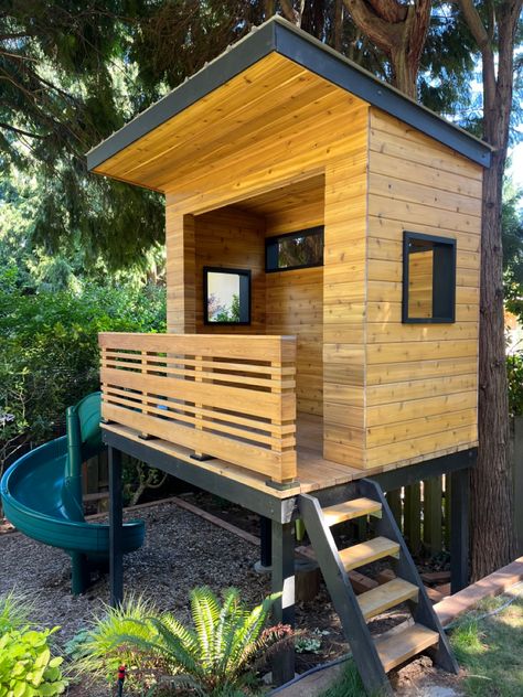 Modern cedar raised platform playhouse built for my kids in our backyard. All the landscaping and construction done by my wife and I. Mid Century Modern Playhouse, Playhouse On Platform, Freestanding Treehouse, Kid Clubhouse, Platform Playhouse, Raised Playhouse, Modern Playhouse, Backyard Fort, Modern Playground