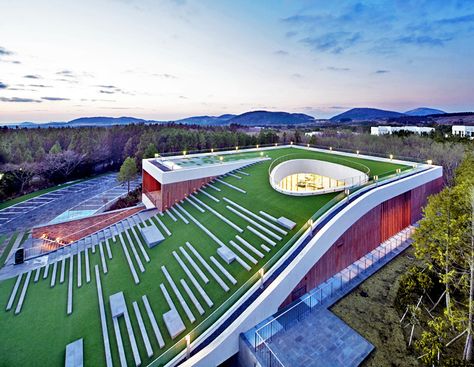 Sloping Green Roof Tops Submerged Multipurpose Hall on Jeju Island Amphitheater Architecture, Green Roof Building, Big Architects, Roof Tops, Multipurpose Hall, Commercial And Office Architecture, Roof Architecture, Building Roof, Green Architecture