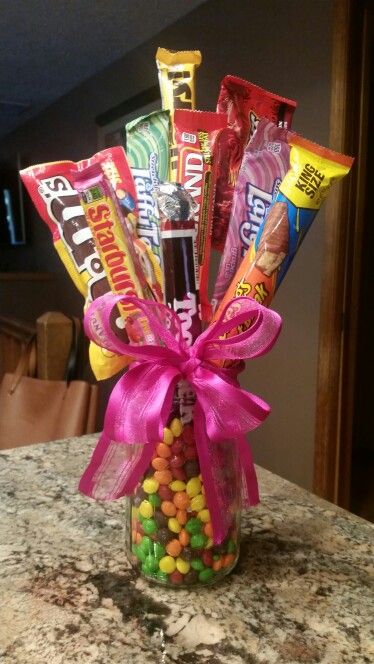 Candy bouquet mason jar and skittles hot glue candy to dowels Mason Jar Candy Bouquet, Sweet Bouquets Candy How To Make, Candy Mason Jar Ideas, Mason Jar Candy Gifts, Candy Bouquet For Kids, How To Make A Candy Bouquet, Candy Centerpiece Ideas, Candy Jar Gifts, Candy Basket Ideas