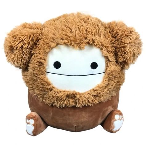 Benny the Bigfoot is a brown Squishmallow exclusive to Target. Benny the big foot. Benny is the smartest creature in the woods. He loves to run and play with his pals. When he is not running around you can often find him taking photographs with woodland friends. Benny is a brown creature with a fuzzy mane on his head and long, shaggy ears. He has white pads on her feet which are shaped like hearts. He has black eyes, a wide mouth which stretches across his face, and a white tooth sticking out of Brown Squishmallow, Bigfoot Squishmallow, Billy Kid, Pillow Pals, Cute Squishies, Woodland Friends, Black Eyes, Cute Stuffed Animals, Birthday Wishlist