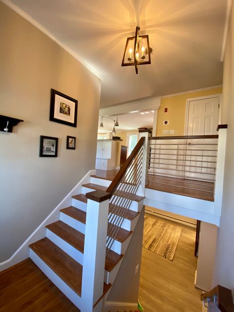 Stairs, railing and balusters replaced in this 1960s split level ranch to update the entryway. Walnut wood and stainless steel. Split Foyer Stairs Remodel, Split Level Finished Basement Ideas, Split Level Railing Ideas Entryway, Staircase Makeover Split Level, Split Level Entryway Railing, Front Porch Design Split Level, Stair Railing Ideas Bilevel, Raised Ranch Railing Ideas, Split Entry Stairs