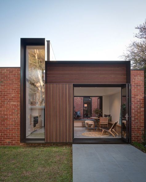 The view from the yard of this modern house addition, showcases the new brickwork that used recycled bricks to tie in with the original house, wood accents, and the deep steel frames. #HouseAddition #Architecture #ModernHouse Recycled Brick, Hillside House, Casa Country, Rear Extension, Brick Walls, Modern Architecture House, Young Couple, Home Additions, House Extensions